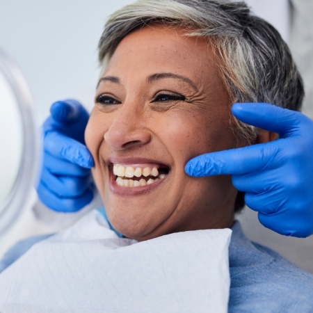 Dental patient looking at their new smile in mirror