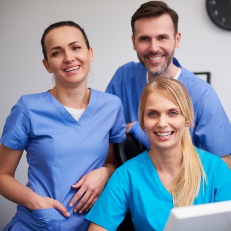 Three smiling dental team members
