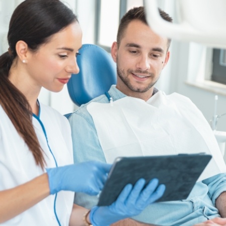 Dental team member showing a tablet to a patient