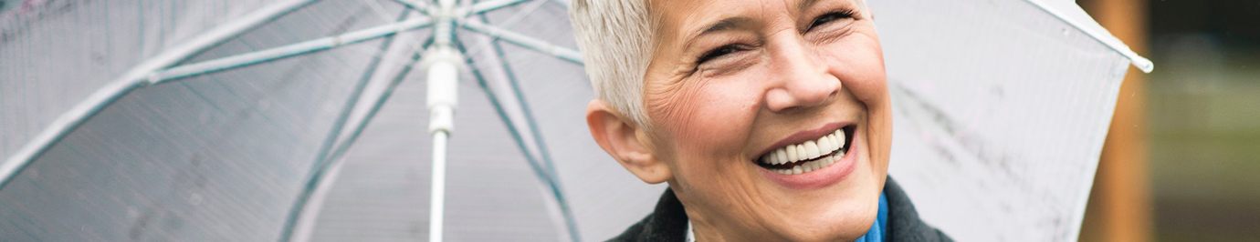 Senior woman holding an umbrella and smiling