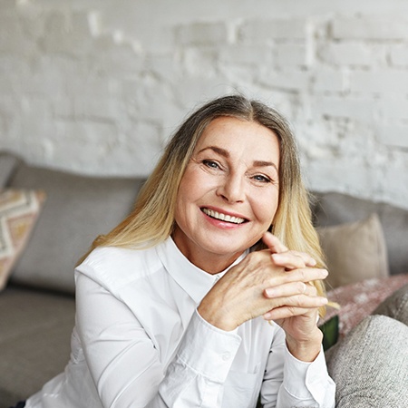 Senior woman sitting on her couch and smiling