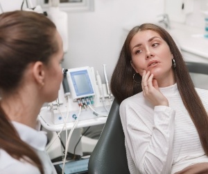 Dental patient holding the side of her face in pain