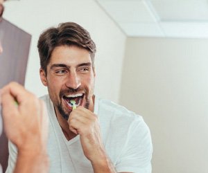 a man brushing his teeth in the morning