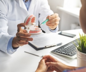 Dentist showing a denture to a patient