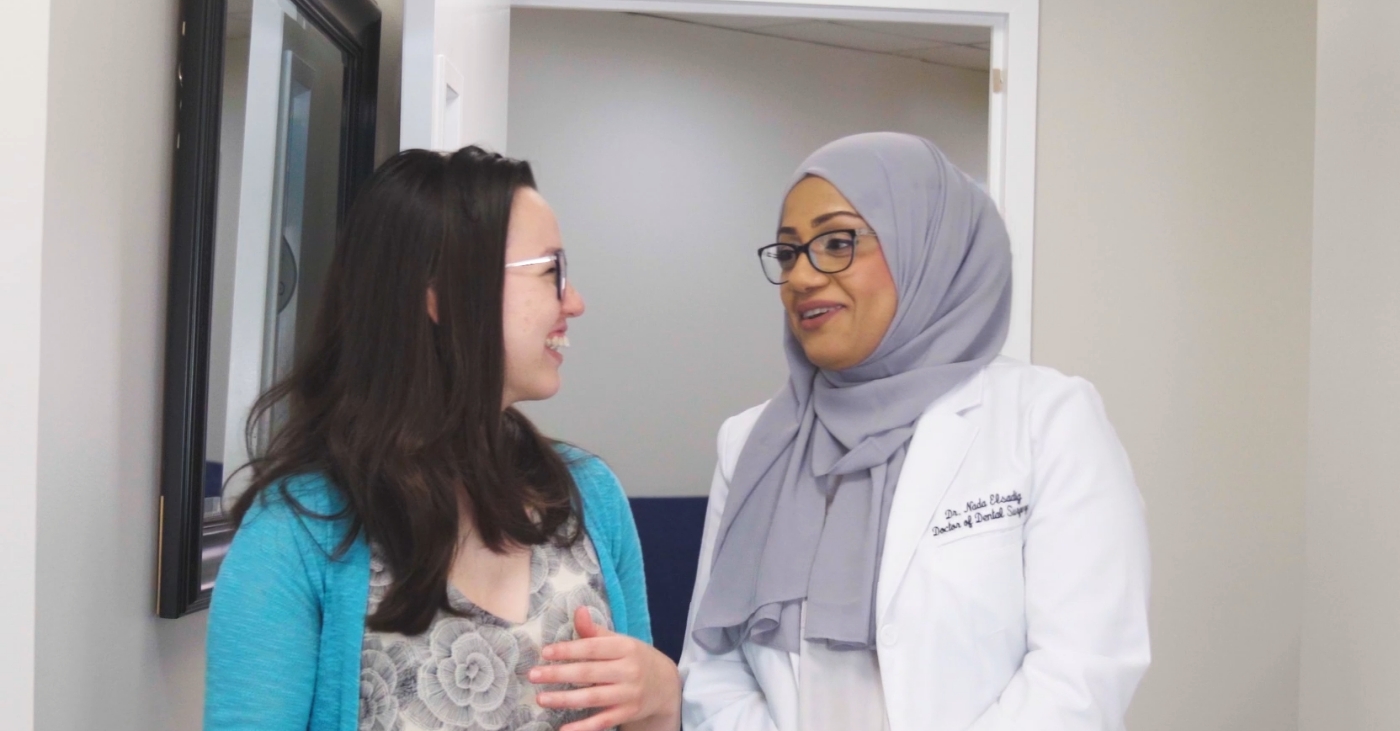 Falls Church dentist talking in a hallway with a dental patient
