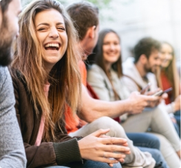 Group of happy young adults sitting in a row