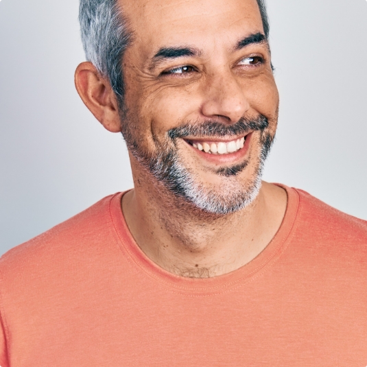 Smiling man in orange shirt with short beard