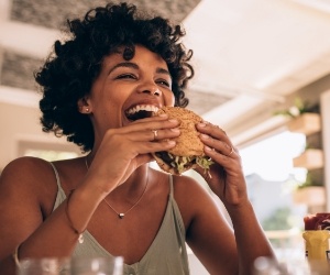 Woman taking a bite of a burger