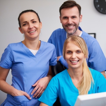 Three smiling dental team members