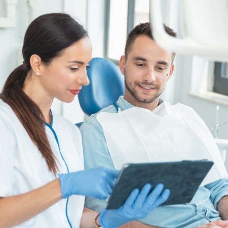 Dental team member showing a tablet to a patient