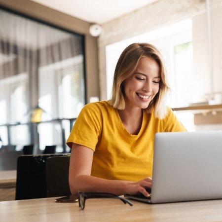 Woman looking at laptop for dentist reviews in Falls Church