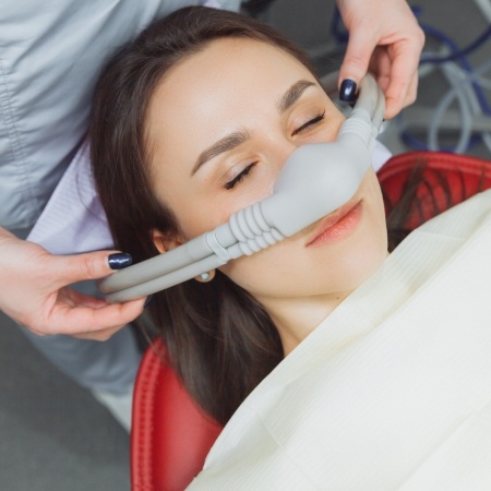 Woman with mask over her nose for nitrous oxide sedation dentistry