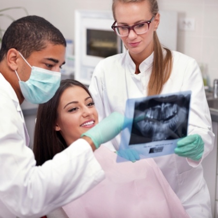 Dentist and assistant showing a patient images of their mouth