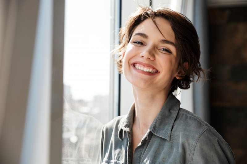 Woman smiling after dental implant surgery